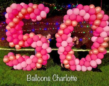 large balloon sculpture  number 50 made with pink and gold balloons on grass