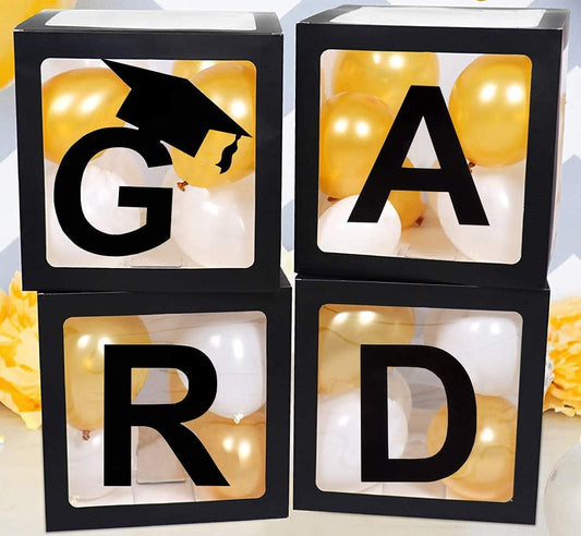 Four transparent black balloon boxes with the letters 'GRAD' and the number  arranged to form a graduation celebration theme, filled with gold and white balloons.