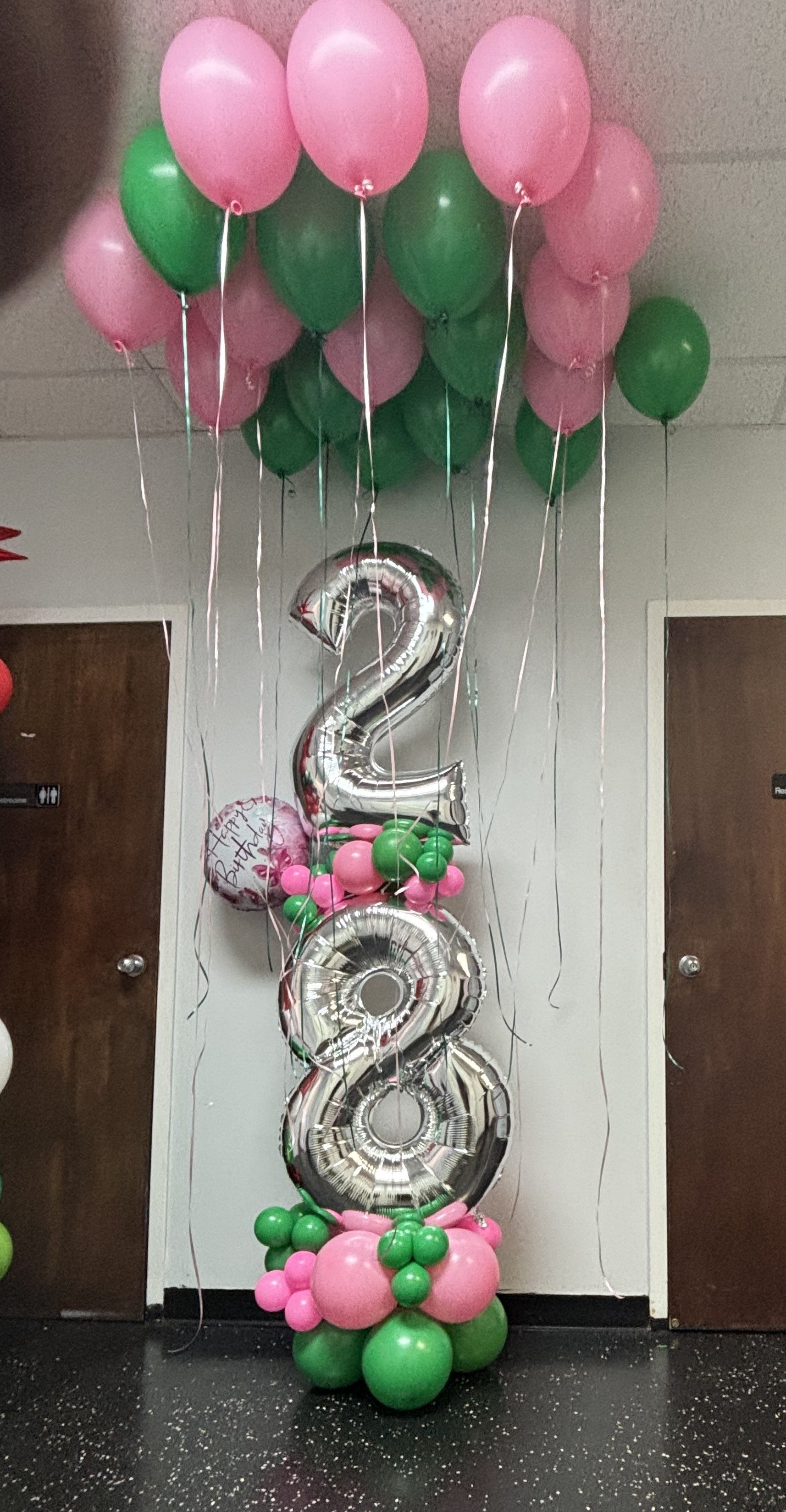 pink and green helium balloons in ceiling, big number balloon column with pink and green latex balloons