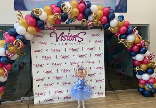 large balloon arch with white gold blue and fuchsia balloons with curly balloon in chrome