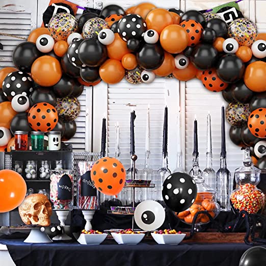 A Halloween-themed balloon garland featuring a variety of balloons with eye patterns and other Halloween motifs of orange, black and polka dot balloons
