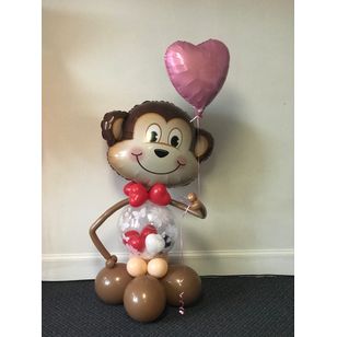 Monkey balloon sculpture with big monkey balloon as head and holding a pink balloon heart